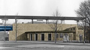 Archiv-Foto (Schwarz-weiß) des Bahnhofs Siemensstadt, Empfangsgebäude und Stahlviadukt eingefärbt